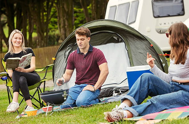 A group of friends enjoying a barbecue outside their tent