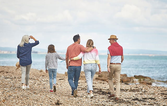 A family walking along a shingle beach