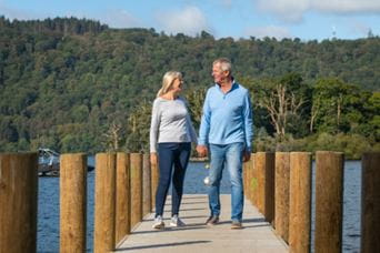 older couple walking down lake boardwalk
