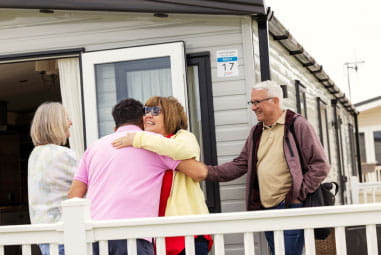 friends greeting each other outside a caravan
