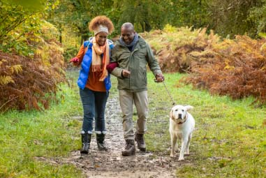 couple walking their dog down a countryside path