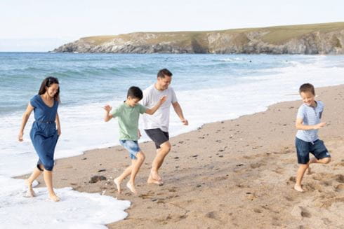 a family running near the water on a picturesque beach