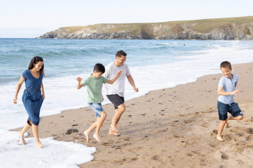 a family running near the water on a picturesque beach
