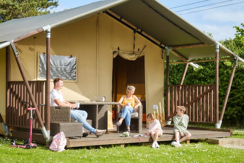 a glamping tent with a family outside