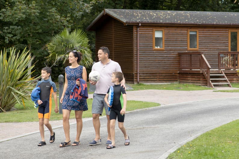 family walking down a path next to a lodge