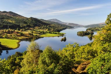 birds eye view of Queens View, a lush green expanse of land and trees with mountains in the background
