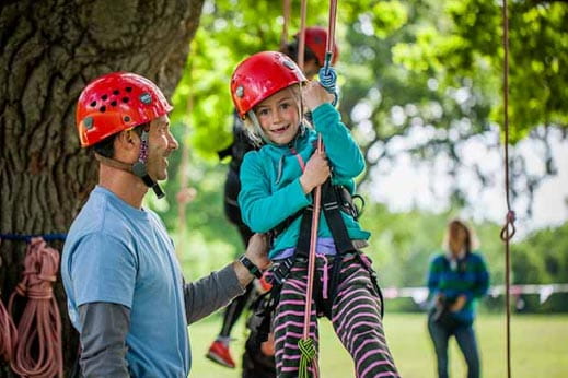 child on a zip wire accompanied by father