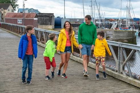 family walking beside a dockland pier