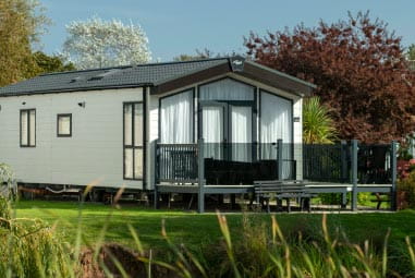 pretty picture of an upscale lodge with trees and greenery in the background