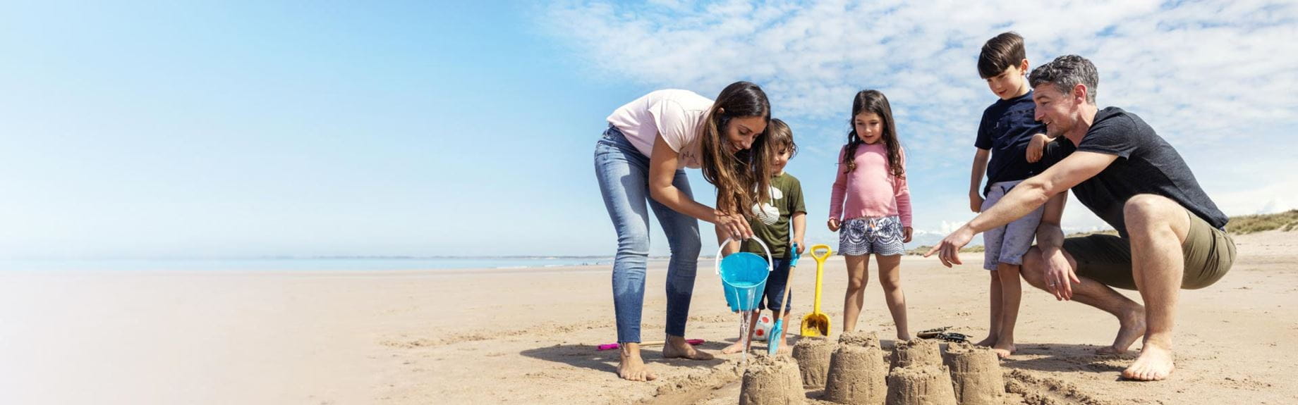 Family building sandcastles on the beach