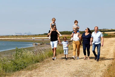 Family walking along the beach with children on shoulders