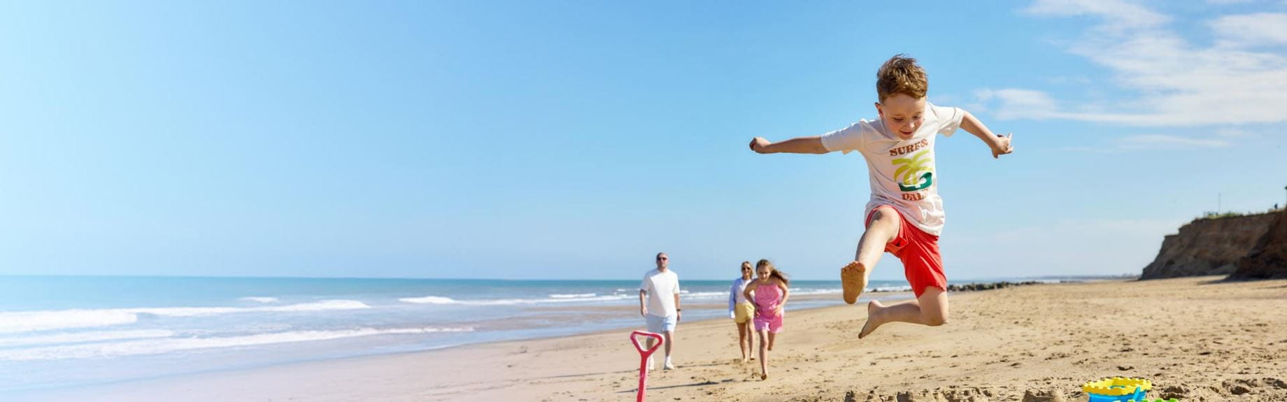 Little boy jumping in the air at the seaside