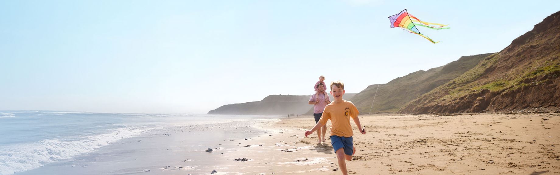 Little boy flying kite on beach