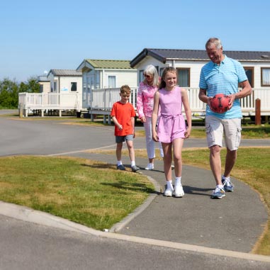 Family walking with ball through Parkdean Resorts