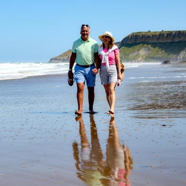 Couple walking hand in hand on beach
