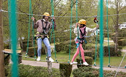 Sandford hero image of 2 people on the high ropes course
