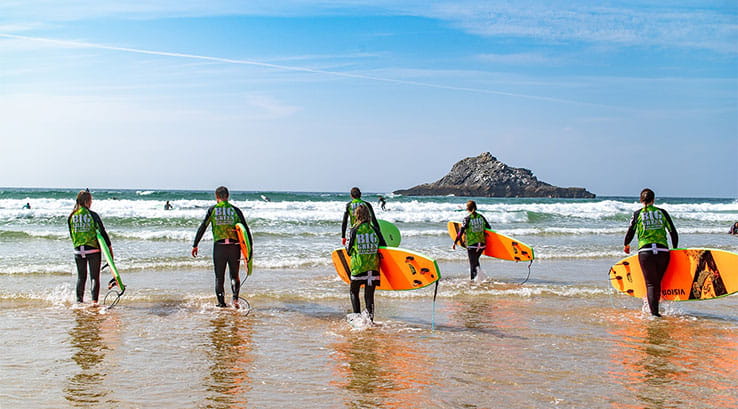 A group surfing lesson on Crantock Beach in Cornwall
