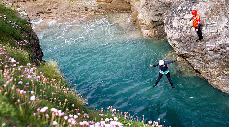 Person jumping off a cliff into the sea