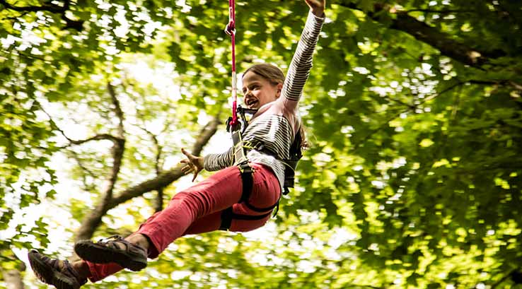 Girl abseiling from a tree