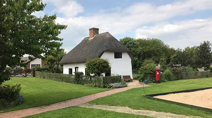 a quaint village farm with a thatched roof