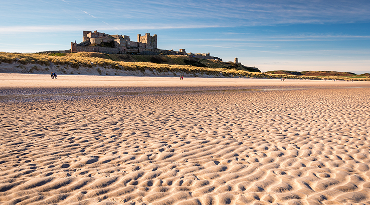 A view across the sands of Bamburgh Beach towards Bamburgh Castle