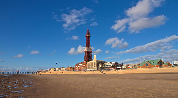 A view across Blackpool Beach of the Tower and pier at dusk