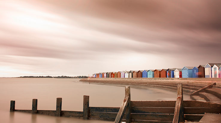 Cloudy skies over the beach huts at Brightlingsea Beach