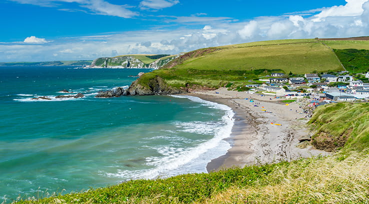 Clifftop view of Challaborough Bay beach on sunny day