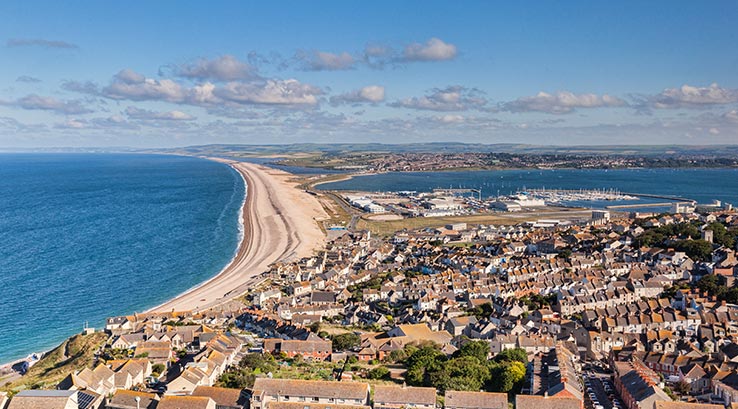 aerial view of chesil cove beach and surrounding town on a glorious day