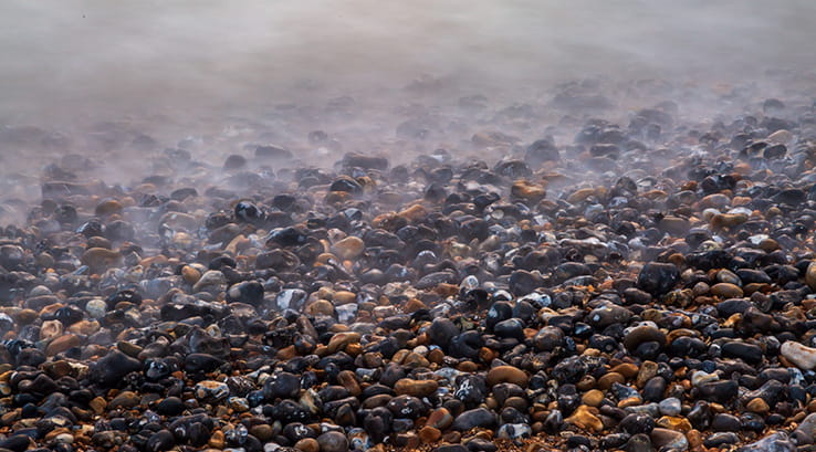 A close up of the shoreline of a pebble beach