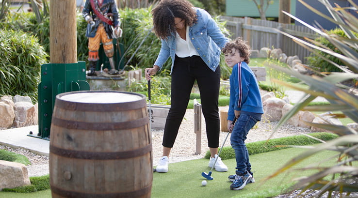 A mother and son playing crazy golf