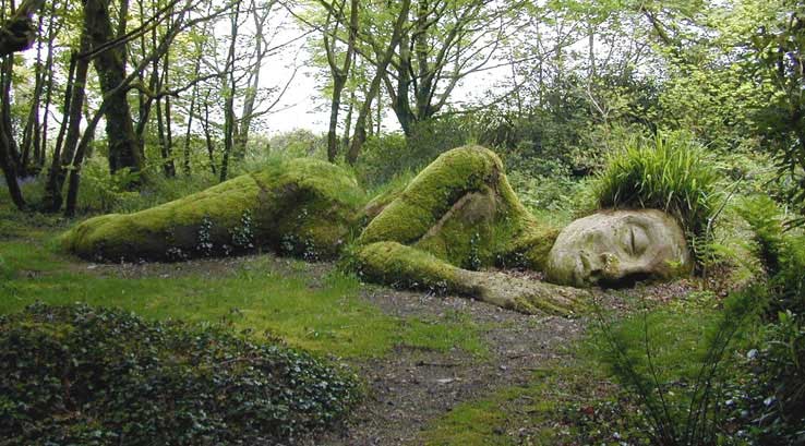 large outdoor sculpture of woman lying in grass