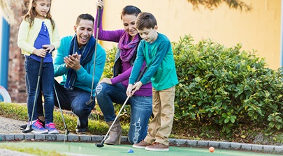 A family playing a game of mini golf