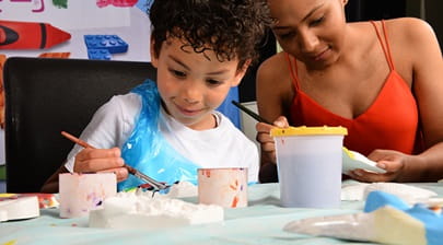 A young boy and woman taking part in pottery painting