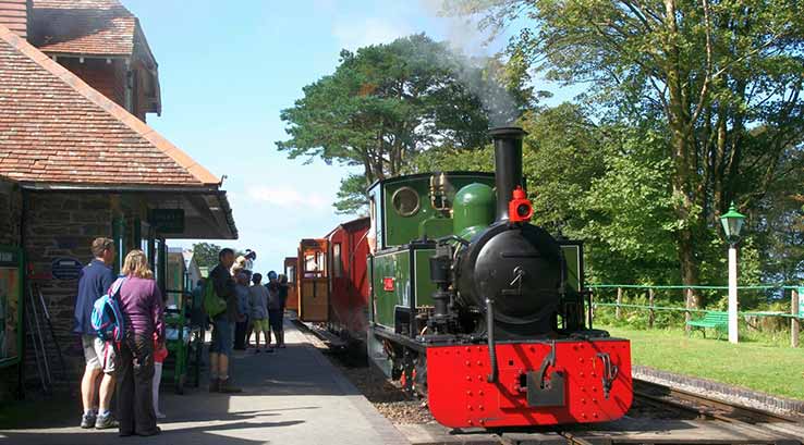 Steam train pulling up to station at Lynton & Barnstaple Railway