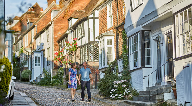 A couple walking down Mermaid Street in Rye