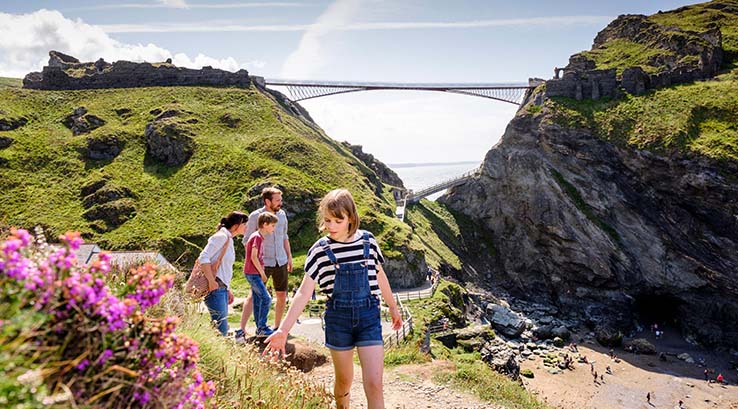 A family exploring the landscape of Tintagel Castle in Cornwall
