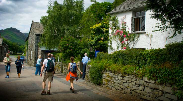 People walking past the exterior of Dove Cottage in the Lake District