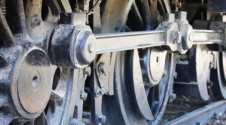 A close up of a steam engine's wheels