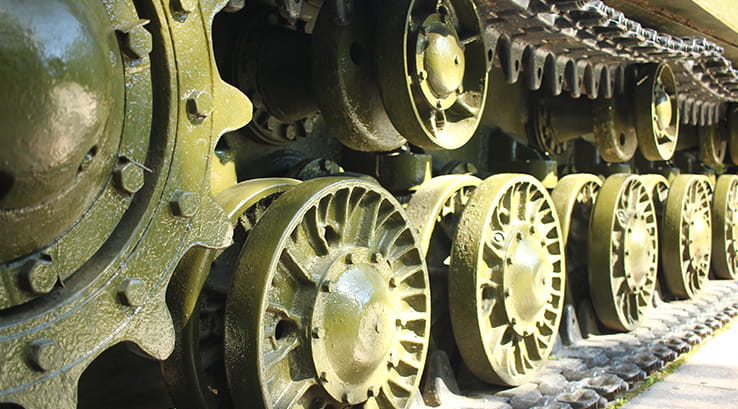 A close up of the wheels and track of a military tank