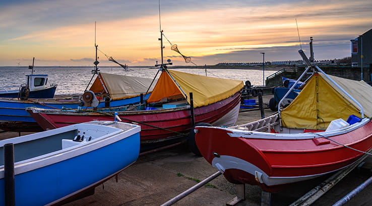 Small boats docked at Newbiggin-by-the-Sea at sunset
