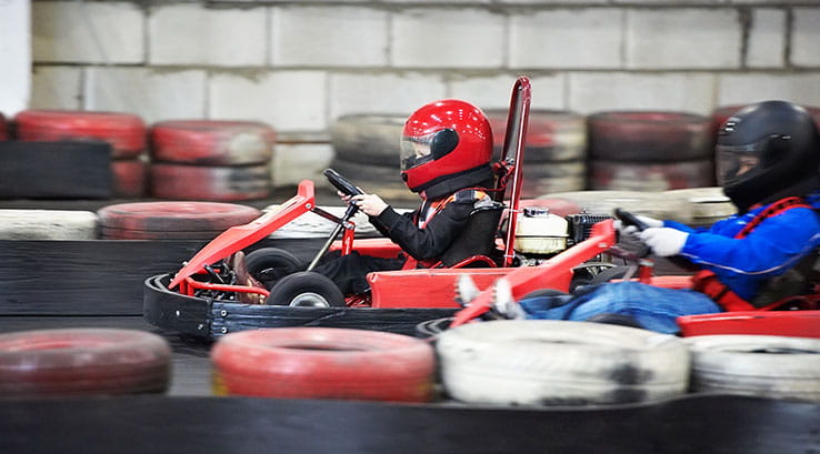 Two kids taking part in indoor go-karting