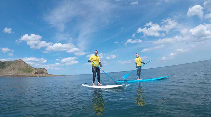 2 people paddleboarding in the sea