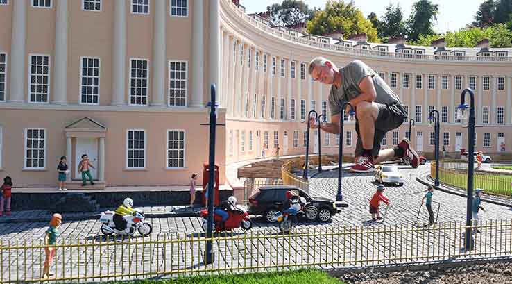 Man crouching down looking at Babbacombe Model Village