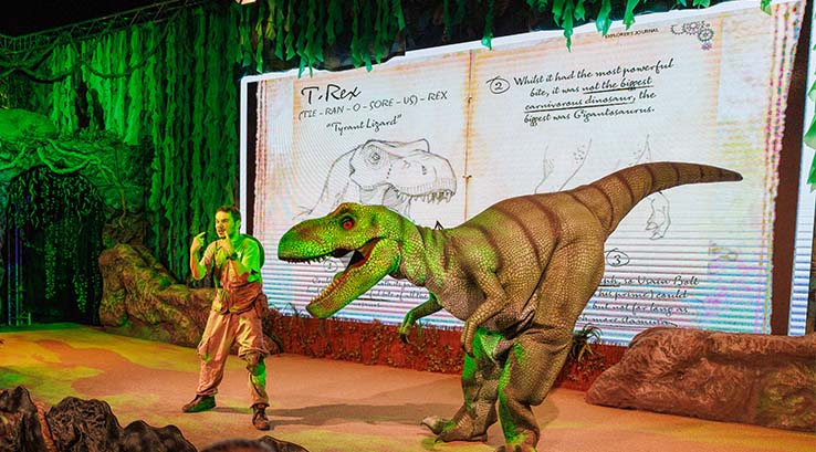 A man and dinosaur on stage at ROARR! in Norfolk