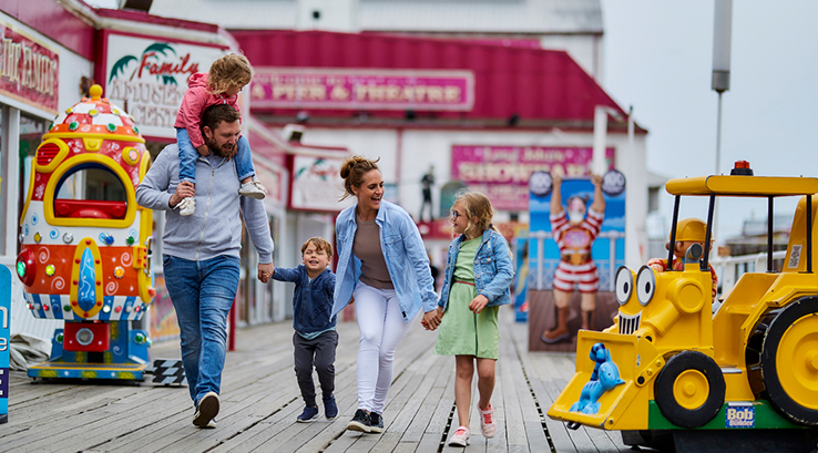 family walking past amusements at the pleasure beach