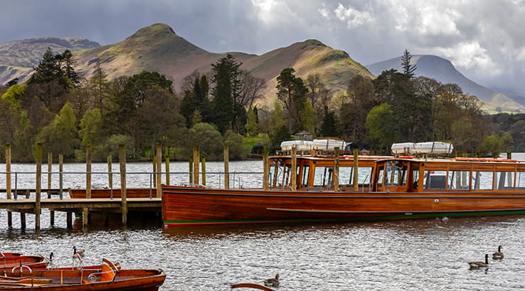 A passenger cruising boat docked at a jetty on Derwentwater, Keswick
