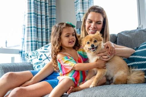 mother and daughter with their small dog in a caravan