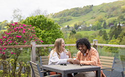A couple relaxing on their lodge veranda at Limefitt Holiday Park in the Lake District