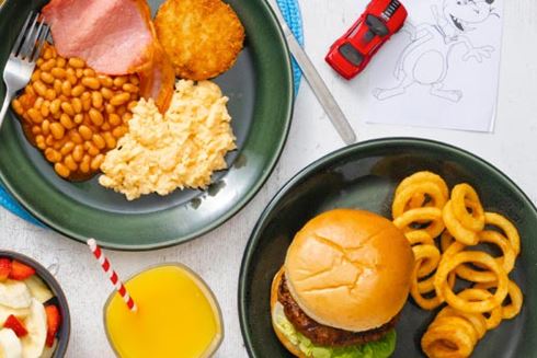 Burger and curly fries and a full English breakfast on plates